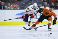 Philadelphia Flyers' Philippe Myers (5) and Washington Capitals' Tom Wilson (43) chase the puck during the second period of an NHL hockey game Wednesday, Jan. 8, 2020, in Philadelphia. (AP Photo/Matt Slocum)