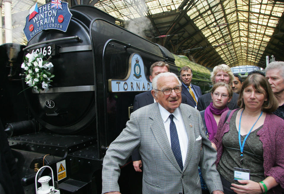 Sir Nicholas Winton (L) stands in front of a steam train with evacuees from Nazi-occupied Czechoslovakia 70 years ago, at Liverpool Street Station, in London, on September 4, 2009. A steam train carrying some of the 669 Jewish children who escaped the Holocaust thanks to a British man dubbed the 