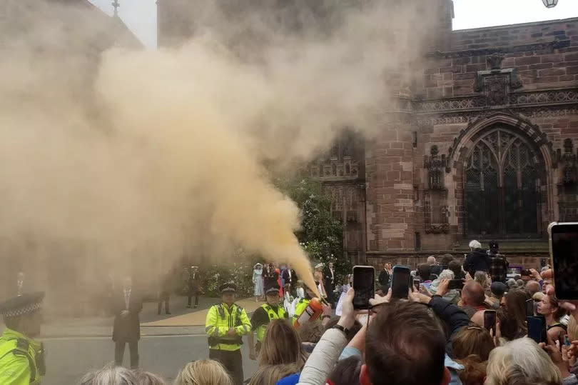 A protester using a fire extinguisher to project powder paint outside Chester Cathedral during the wedding of Hugh Grosvenor, the Duke of Westminster, and Olivia Henson -Credit:PA