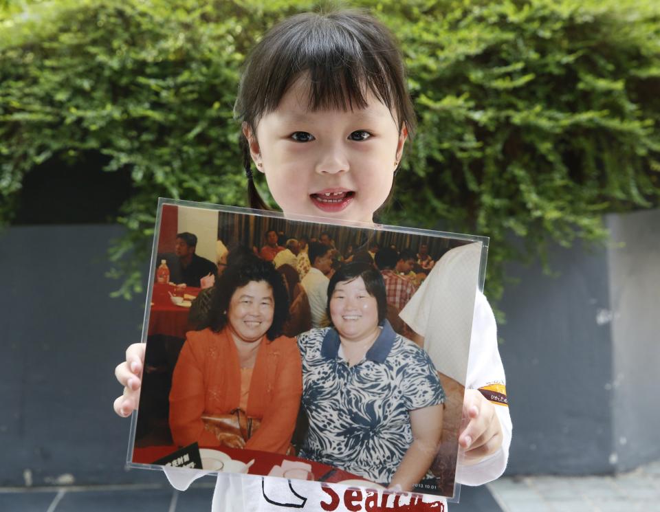 Jie Yie holds a picture of her grandmother Lee Sew Chu and her aunt Ng May Li who were aboard missing Malaysia Airlines flight MH370, on the one year anniversary of its disappearance at a remembrance event, in Kuala Lumpur