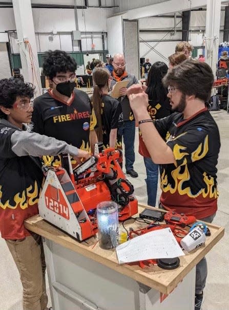 The South Bend area-based Fire Wires robotics team makes adjustments at a competition.