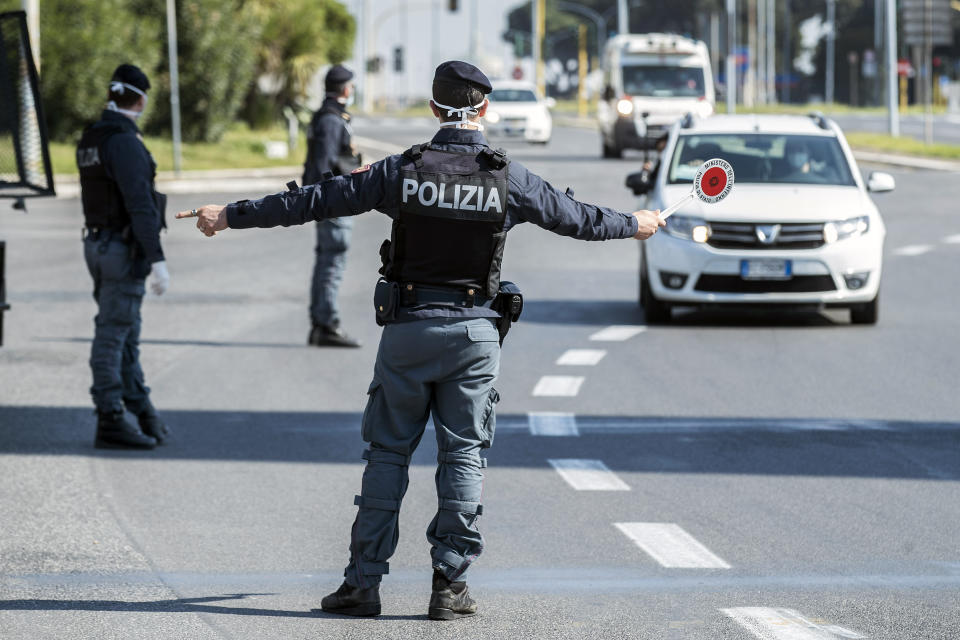 Police officers stop and check vehicles in Rome, Saturday, April 11, 2020. Using helicopters, drones and stepped-up police checks to make sure Italians don't slip out of their homes for the Easter holiday weekend, Italian authorities are doubling down on their crackdown against violators of the nationwide lockdown decree. The new coronavirus causes mild or moderate symptoms for most people, but for some, especially older adults and people with existing health problems, it can cause more severe illness or death. (Roberto Monaldo/LaPresse via AP)