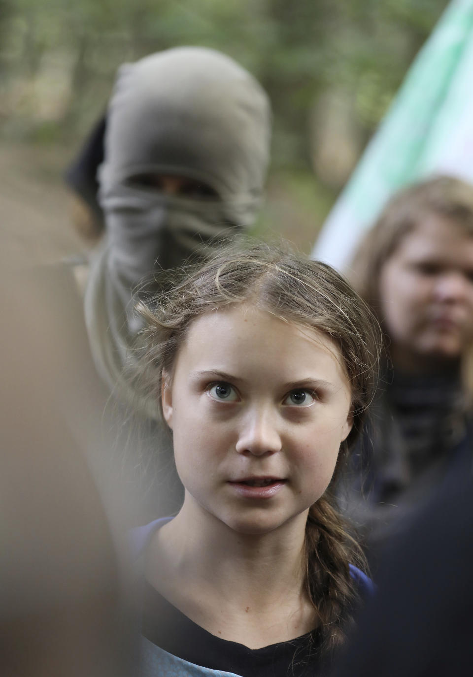 Climate activist Greta Thunberg, center, stands together with environmentalist protesters as she visits the ancient Hambach Forest near the city of Kerpen in western Germany, Aug. 10, 2019. The teenage activist who is a leading figure in the Fridays for Future strikes against climate said that seeing the open-cast lignite pit in Hambach disturbed her deeply and that the time has come to stop talking and take action. (Oliver Berg/dpa via AP)