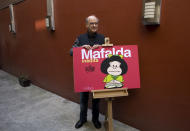 FILE - In this Nov. 26, 2008 file photo, Argentine cartoonist Joaquin Salvador Lavado, better known as "Quino," poses with his character Mafalda during a news conference in Mexico City. Lavado passed away on Wednesday, Sept. 30, 2020, according to his editor Daniel Divinsky who announced it on social media. (AP Photo/Dario Lopez-Mills, File)