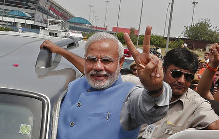 Hindu nationalist Narendra Modi, the prime ministerial candidate for India's Bharatiya Janata Party (BJP), gestures towards his supporters from his car during a road show upon his arrival at the airport in New Delhi May 17, 2014. REUTERS/Adnan Abidi