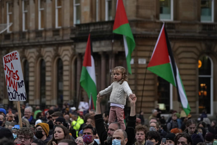 A child stands on the shoulders of an adult as climate activists gather at the end of a march through the streets of Glasgow, Scotland, Friday, Nov. 5, 2021 which is the host city of the COP26 U.N. Climate Summit. The protest was taking place as leaders and activists from around the world were gathering in Scotland's biggest city for the U.N. climate summit, to lay out their vision for addressing the common challenge of global warming. (AP Photo/Alberto Pezzali)