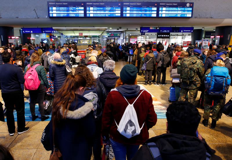 People wait inside the main railway station of Cologne as trains are cancelled due to storm Sabine