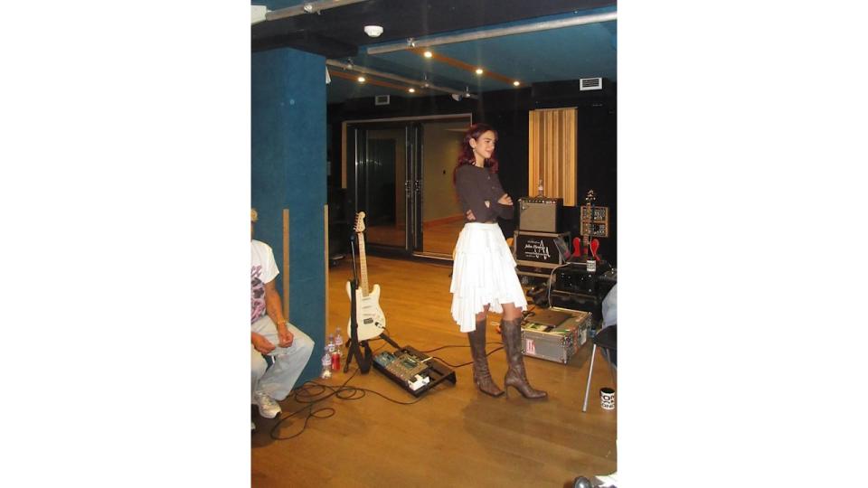 Dua Lipa shares an image of herself in the music studio wearing knee-high boots and a white skirt