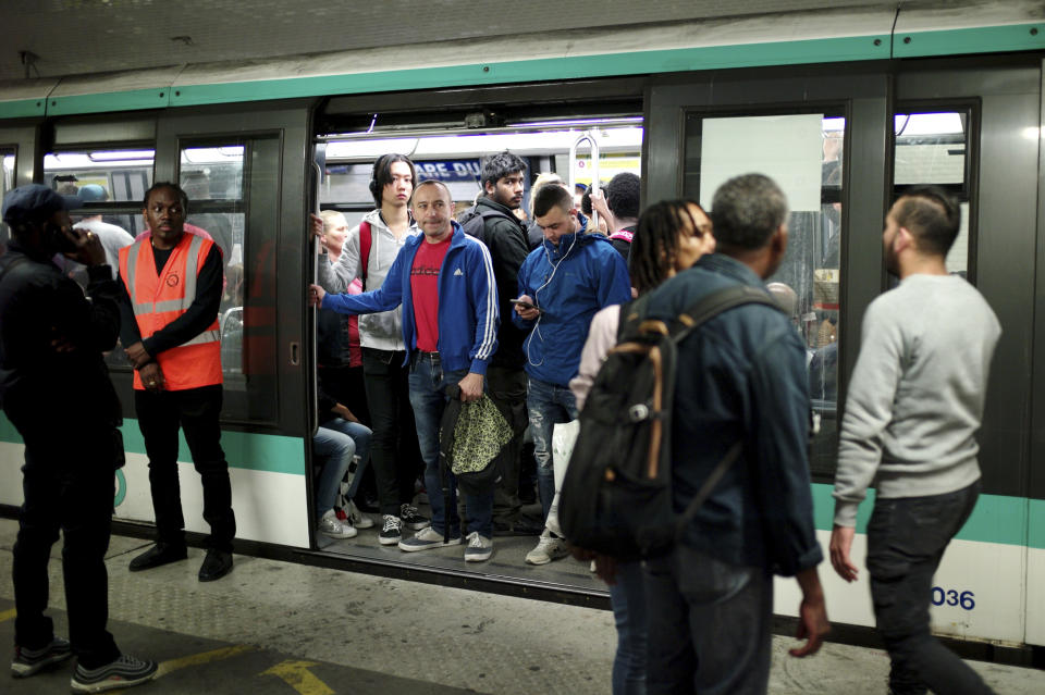 Commuters board a train, in Gare du Nord railway station, in Paris, Friday, Sept. 13, 2019. Paris metro warns over major strike, transport chaos Friday. (AP Photo/Thibault Camus)