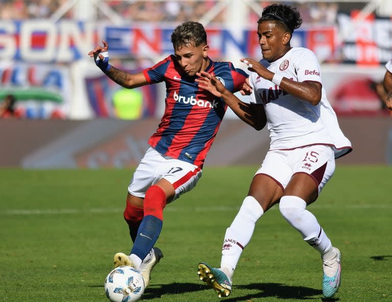 Elián Irala, juvenil mediocampista de San Lorenzo, disputa la pelota con el colombiano Raúl Loaiza; como visitante, Lanús sorprendió en el final.