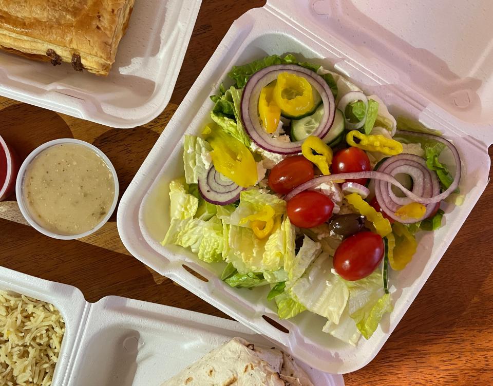 The Greek salad was topped with tomato, cucumbers, kalamata olives and red onions with a side of Greek dressing and a sprinkle of feta cheese.