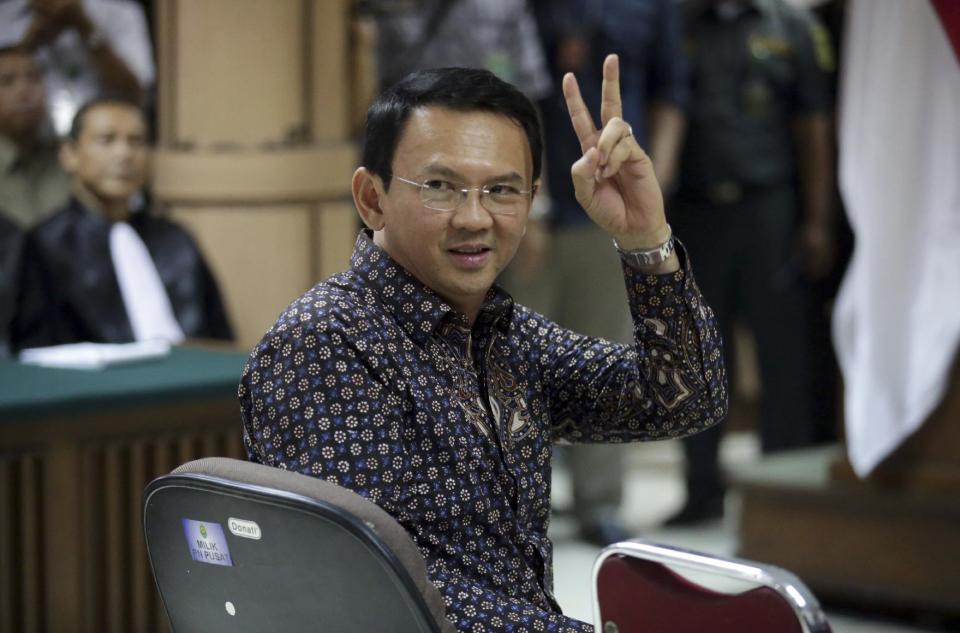 Jakarta Governor Basuki "Ahok" Tjahaja Purnama gestures to visitors inside a courtroom during his trial at North Jakarta District Court in Jakarta, Indonesia, Tuesday, Dec. 27, 2016. The court ruled Tuesday that the blasphemy trial of the minority Christian governor of the country's capital will proceed. (Bagus Indahono/Pool Photo via AP)