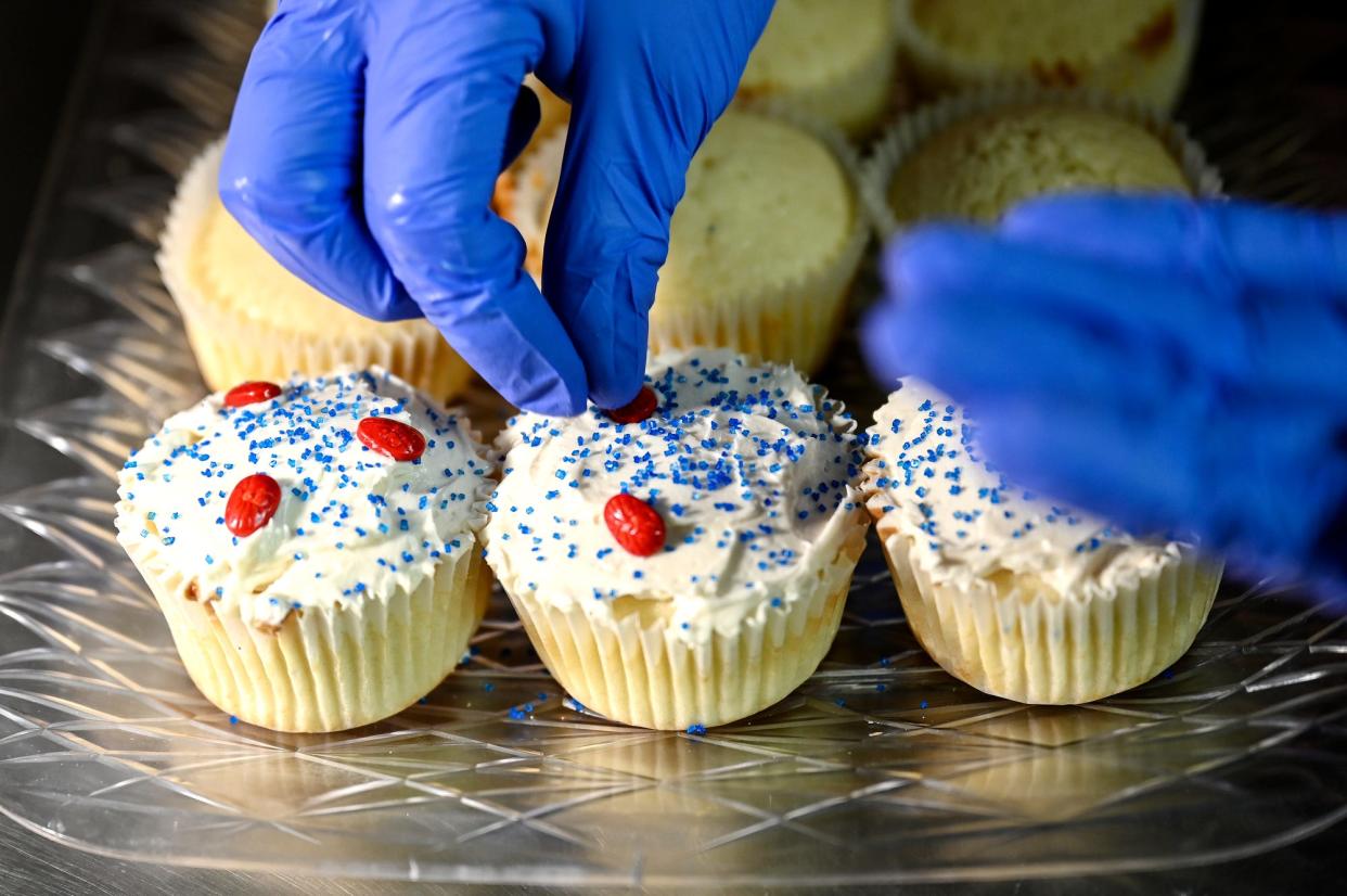 Jenniffer Reaser, owner of Delicious Delights Cakes, decorates cupcakes on Friday, Aug. 3, 2022, at her bakery at the Lansing Mall.