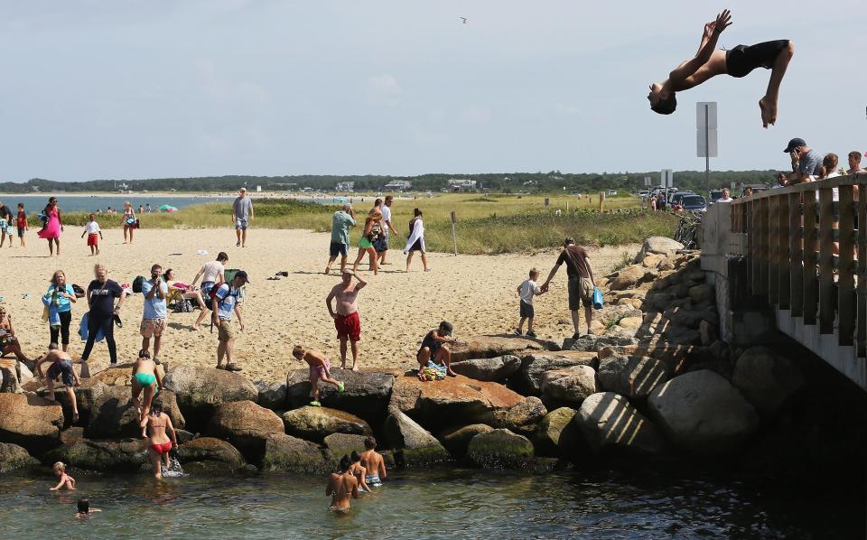 A boy jumps off 'Jaws Bridge' during JawsFest: