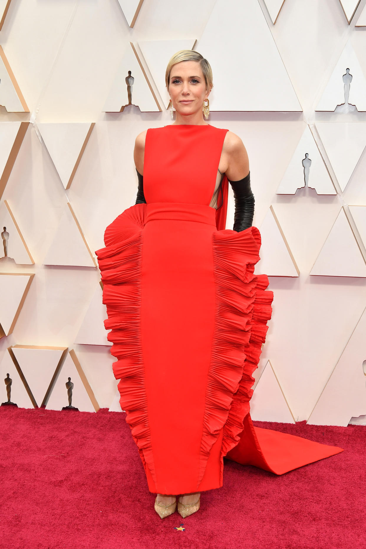 Kristen Wiig wears a red dress on the red carpet at the 92nd Annual Academy Awards at Hollywood and Highland on February 09, 2020 in Hollywood, California