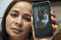 In this Wednesday, Feb. 26, 2020 photo, Yarelis Gutierrez Barrios holds up a cell phone photo at her home in Tampa, Fla., of herself with her partner Roylan Hernandez Diaz, a Cuban asylum seeker who hanged himself in a Louisiana prison. An Associated Press investigation into Hernandez’s death last October found neglect and apparent violations of government policies by jailers under U.S. Immigration and Customs Enforcement. (AP Photo/Chris O'Meara)