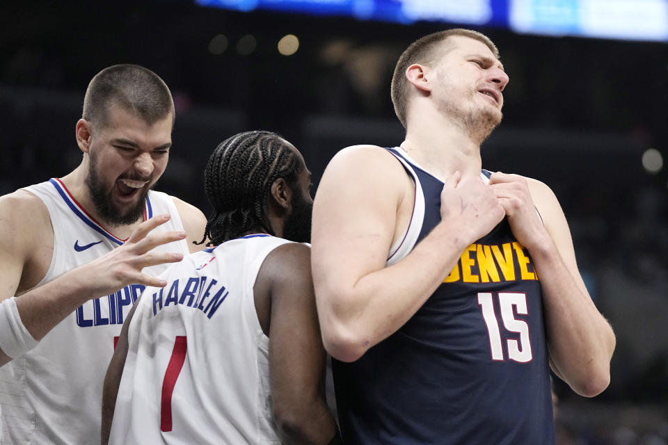 Los Angeles Clippers guard James Harden, center, celebrates with center Ivica Zubac, left, after scoring as Denver Nuggets center Nikola Jokic reacts to getting a foul called against him during the second half of an NBA basketball game Thursday, April 4, 2024, in Los Angeles. (AP Photo/Mark J. Terrill)