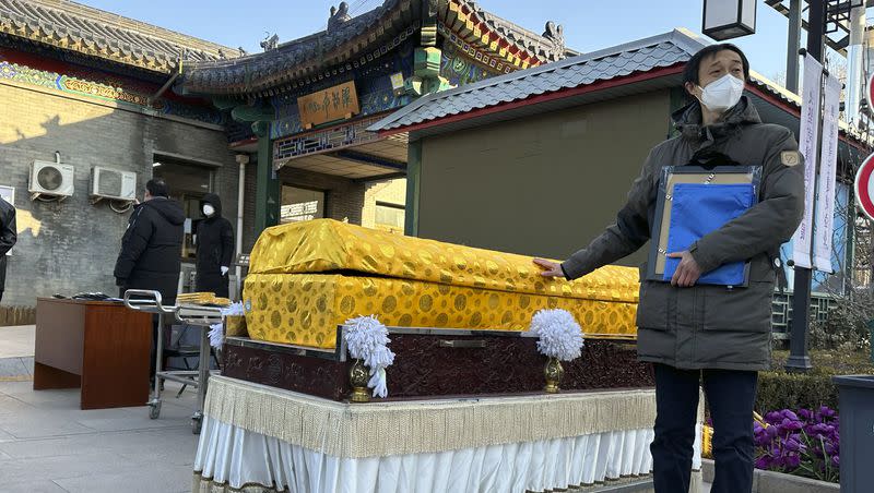 Family members in protective gear collect the cremated remains of their loved one bundled with yellow cloth at a crematorium in Beijing on Dec. 17, 2022. China’s sudden reopening after two years holding to a “zero-COVID” strategy left older people vulnerable and hospitals and pharmacies unprepared during the season when the virus spreads most easily, leading to many avoidable deaths, The Associated Press has found.
