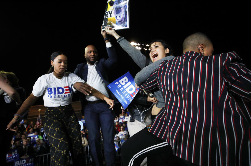 LOS ANGELES, CALIFORNIA - MARCH 03: A protestor (2nd R) charges the stage holding a sign that reads 'Let Dairy Die', as Democratic presidential candidate former Vice President Joe Biden speaks at a Super Tuesday campaign event at Baldwin Hills Recreation Center on March 3, 2020 in Los Angeles, California. After his make-or-break victory in South Carolina, Biden has continued to do well in the Super Tuesday primaries. (Photo by Mario Tama/Getty Images)