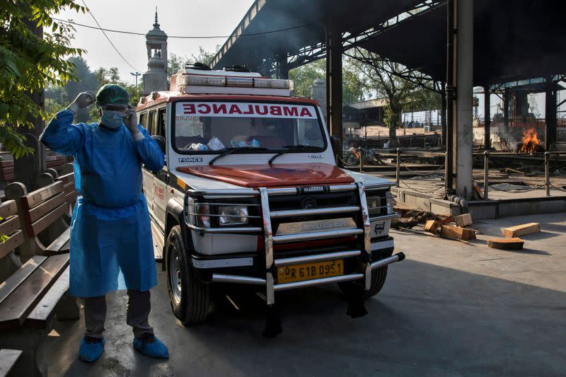 Mohammad Aamir Khan, an ambulance driver, waits for the relatives to unload the bodies of people who died due to the coronavirus disease for their cremation at a crematorium in New Delhi