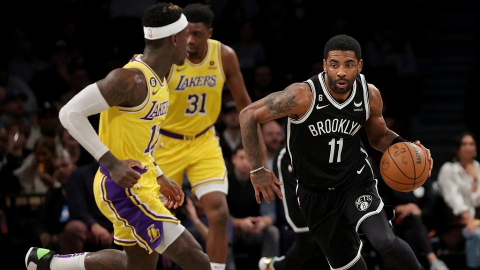 Jan 30, 2023;  Brooklyn, New York, USA;  Brooklyn Nets guard Kyrie Irving (11) brings the ball up court against Los Angeles Lakers guard Dennis Schroder (17) during the first quarter at Barclays Center.