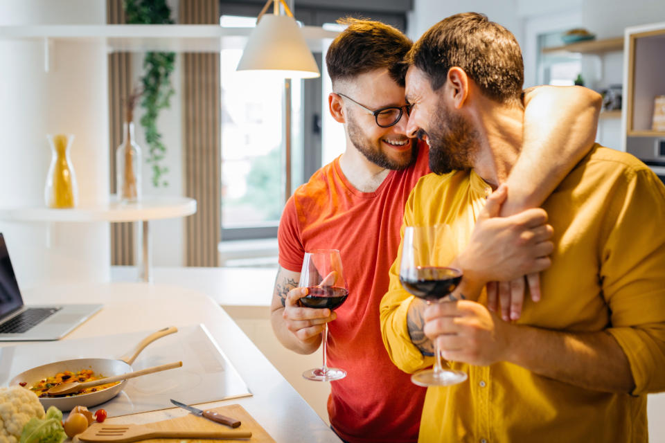 couple hugging while cooking dinner