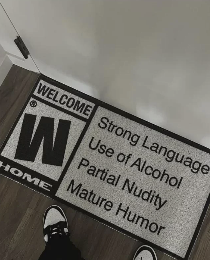 A doormat with content warning labels such as "Strong Language" and "Mature Humor"