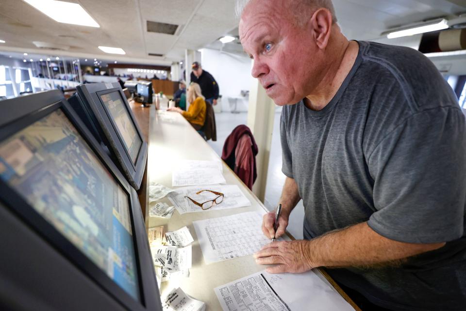 With slips of wagers from other horse racing he was betting on, Darrell Smith, 74, of Royal Oak, watches another race on TV and takes notes at Northville Downs on Saturday, Feb. 3, 2024. The horse racing track that he has been coming to for the past 54 years had its last race on this night.