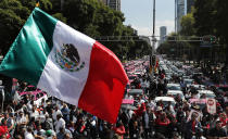Una bandera mexicana ondea mientras cientos de taxistas se reúnen para protestar contra apps que ofrecen transporte en Ciudad de México el lunes 7 de octubre de 2019. (AP Foto/Marco Ugarte)