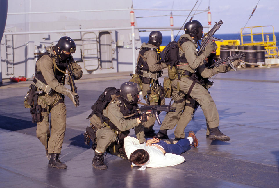 SEALs armed with MP5s and shotguns take down a crew member of a ship they boarded during a training exercise aboard the USS Mount Whitney in the early 90's.  VBSS as it's know for – Visit, Board, Search and Seizure, is one of a number of way of dealing with piracy and ship transporting illegal arms.  Photo: Greg E. Mathieson Sr.  / NSW Publications, LLC