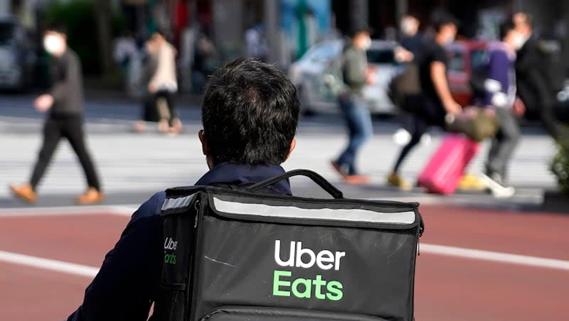 In this April 28, 2021, file photo, an Uber Eats delivery person rides a bicycle through the Shinjuku district in Tokyo, Japan. A new report from Sift shows that food delivery services and rewards accounts are targeted by hackers more often than other types of services.