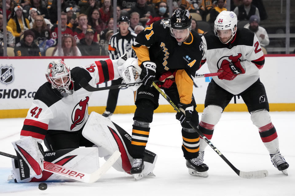 New Jersey Devils goaltender Vitek Vanecek (41) blocks a shot with Pittsburgh Penguins' Evgeni Malkin (71) looking for a rebound while defended by Devils' Colin Miller, right, during the second period of an NHL hockey game in Pittsburgh, Thursday, Nov. 16, 2023. (AP Photo/Gene J. Puskar)