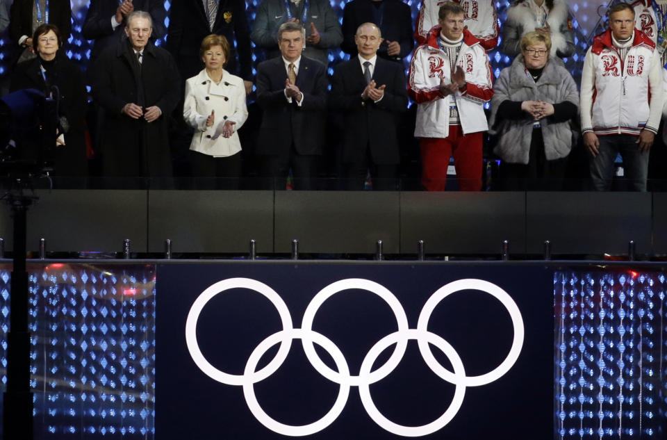 FILE - Anne Rogge, former International Olympic Committee (IOC) President Jacques Rogge, Claudia Bach, IOC President Thomas Bach and Russian President Vladimir Putin, from left, applaud at the closing ceremony of the 2014 Winter Olympics, in Sochi, Russia on Sunday, Feb. 23, 2014. When Russia hosted the Sochi Games, it sought to impress the world and expand its global clout with the most expensive Olympics ever. (AP Photo/Gregorio Borgia, File)