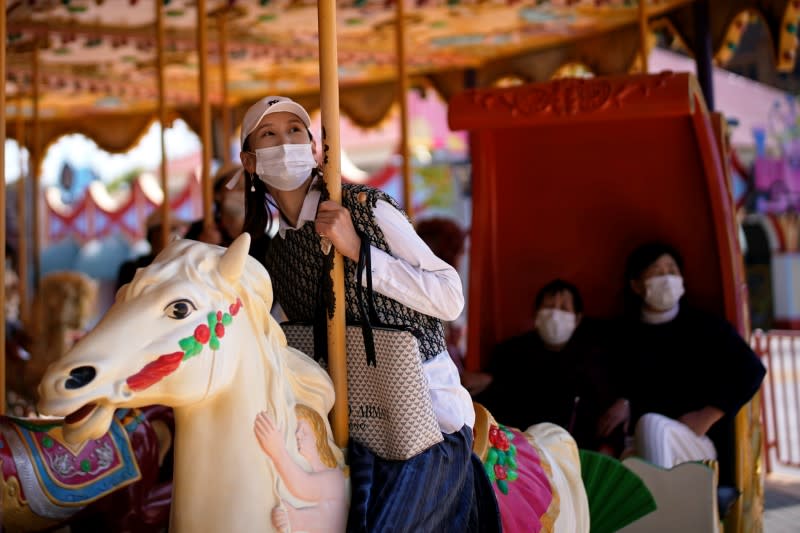 People wearing protective face masks are seen at the Happy Valley amusement park on its first day of opening following the outbreak of coronavirus disease (COVID-19), in Shanghai