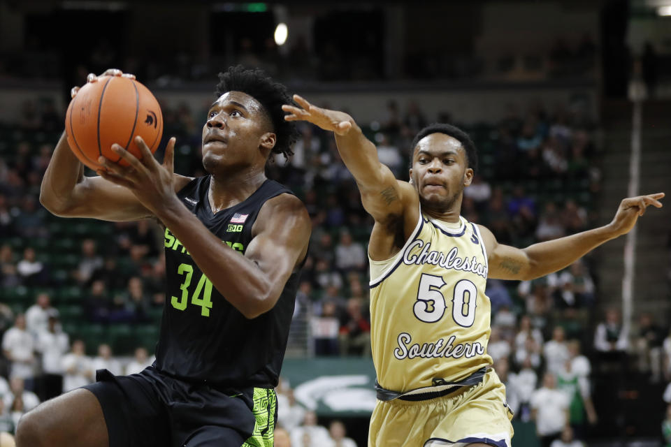 Michigan State forward Julius Marble (34) makes a layup as Charleston Southern guard Malik Battle (50) defends during the second half of an NCAA college basketball game, Monday, Nov. 18, 2019, in East Lansing, Mich. (AP Photo/Carlos Osorio)