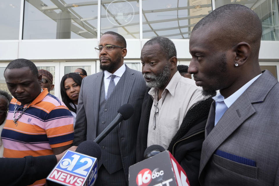 Melvin Jenkins, second from right, speaks to reporters while standing with lead civil attorney Malik Shabazz, second from left, and his son Michael Corey Jenkins, right, on the sentencing of the third of six former Rankin County law enforcement officers, who committed numerous acts of racially motivated, violent torture on his son Michael and his friend Eddie Terrell Parker in 2023., while outside the federal courthouse in Jackson, Miss., Wednesday, March 20, 2024. Daniel Opdyke was sentenced to 17.5 years in federal prison for his actions. (AP Photo/Rogelio V. Solis)