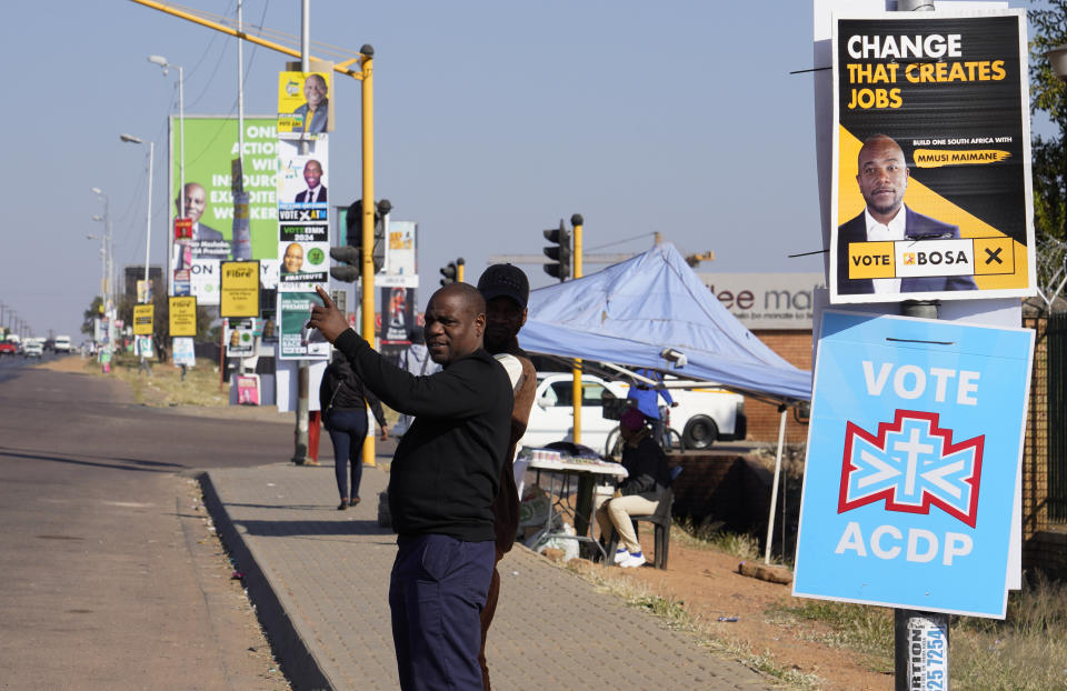 A man waits for a minibus taxi along a street lined with election posters in the Hammanskraal township, Pretoria, South Africa, Wednesday, May 22, 2024. Hammanskraal’s problems are a snapshot of the issues affecting millions and driving a mood of discontent in South Africa that might force its biggest political change in 30 years in next week’s national election.(AP Photo/Denis Farrell)