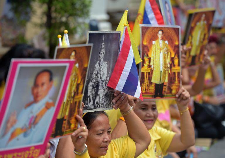 Well-wishers hold portraits of Thai King Bhumibol Adulyadej outside Siriraj hospital in Bangkok, on May 5, 2015