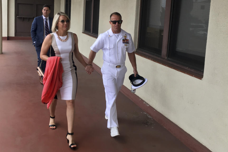 Navy Special Operations Chief Edward Gallagher, right, walks with his wife, Andrea Gallagher as they arrive for military court on Naval Base San Diego, Tuesday, June 18, 2019, in San Diego. Jury selection continued Tuesday morning in the court-martial of the decorated Navy SEAL, who is accused of stabbing to death a wounded teenage Islamic State prisoner and wounding two civilians in Iraq in 2017. He has pleaded not guilty to murder and attempted murder, charges that carry a potential life sentence. (AP Photo/Julie Watson)