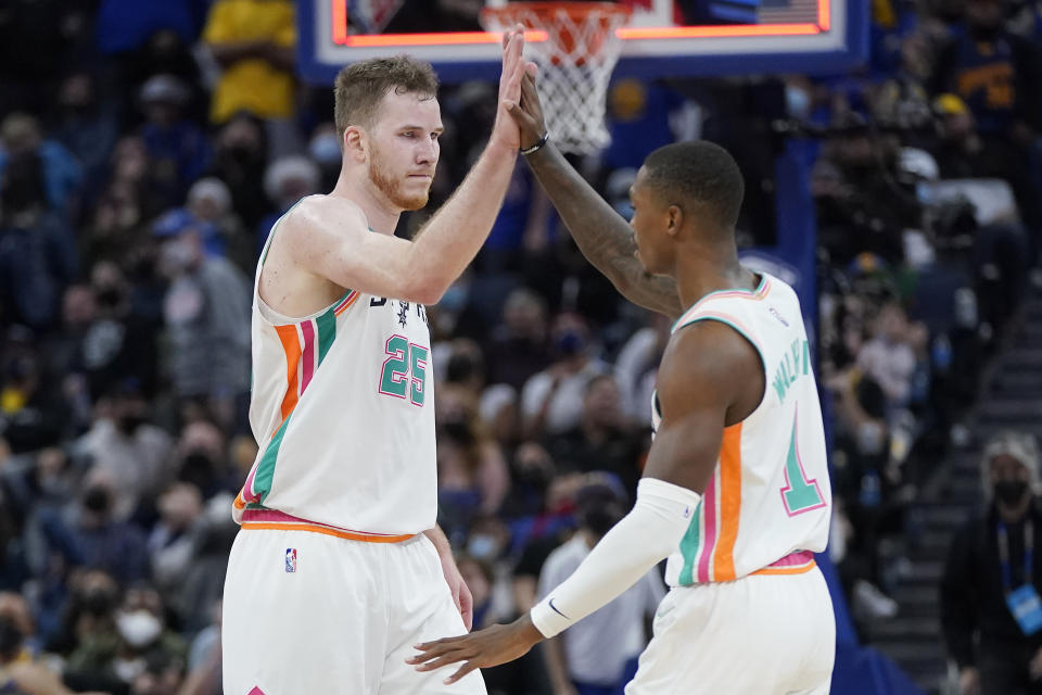 San Antonio Spurs center Jakob Poeltl (25) celebrates with guard Lonnie Walker IV after the Spurs defeated the Golden State Warriors in an NBA basketball game in San Francisco, Saturday, Dec. 4, 2021. (AP Photo/Jeff Chiu)