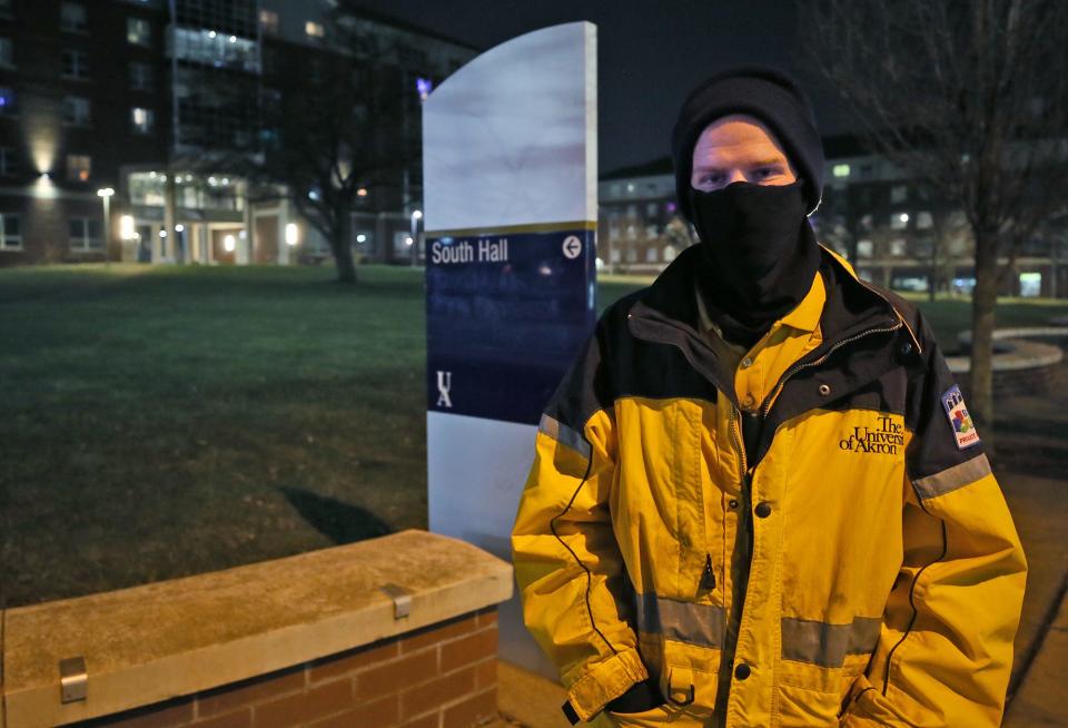 Zack Brown, a Block by Block ambassador, stops in front of University of Akron's Exchange Street Residence Hall.