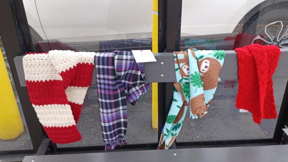 PHOTO: During the winter months, Suzanne Volpe and members of the Scarf Bombardiers “bombard” bus shelters and railings outside of public buildings like churches with handmade scarves for anyone to take and use. (Courtesy of Suzanne Volpe)