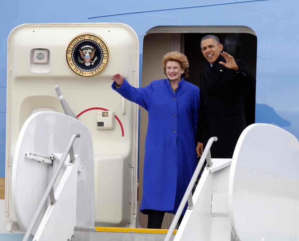 President Barack Obama, and Senate Agriculture Committee Chair Sen. Debbie Stabenow, D-Mich. wave from Air Force One upon their arrival at Capital City Airport in Lansing, Mich., Friday, Feb. 7, 2014. (AP Photo/Duane Burleson)