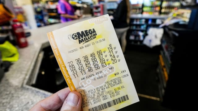 A Mega Millions ticket is seen as a person makes a purchase inside a convenience store.