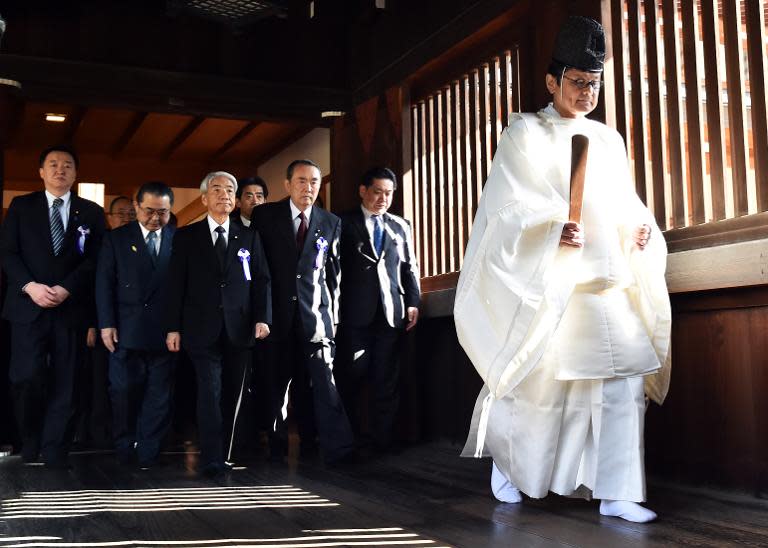 Japanese lawmakers follow a Shinto priest during a visit to the Yasukuni shrine to honour the war dead, in Tokyo, on April 22, 2015