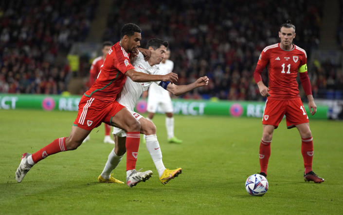 Wales' Ben Davies, left, challenges for the ball with Poland's Robert Lewandowski during the UEFA Nations League soccer match between Wales and Poland at the Cardiff City Stadium in Cardiff, Wales, Sunday, Sept. 25, 2022. (AP Photo/Frank Augstein)
