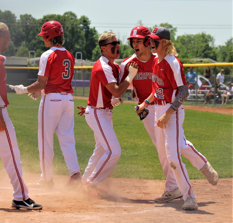 Bedford's Ethan Brickner celebrates at home plate with his teammates after hitting a home run against Monroe in the Division 1 District semifinals last year.