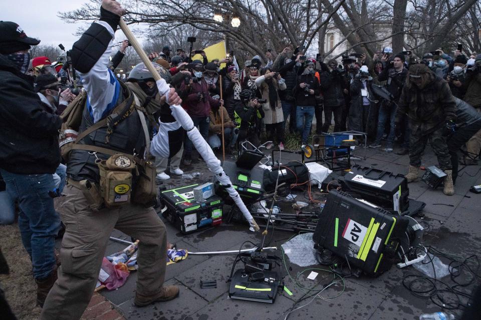 Manifestantes destruyen equipo de televisión frente al Capitolio el miércoles 6 de enero de 2021, en Washington. (AP Foto/José Luis Magaña)