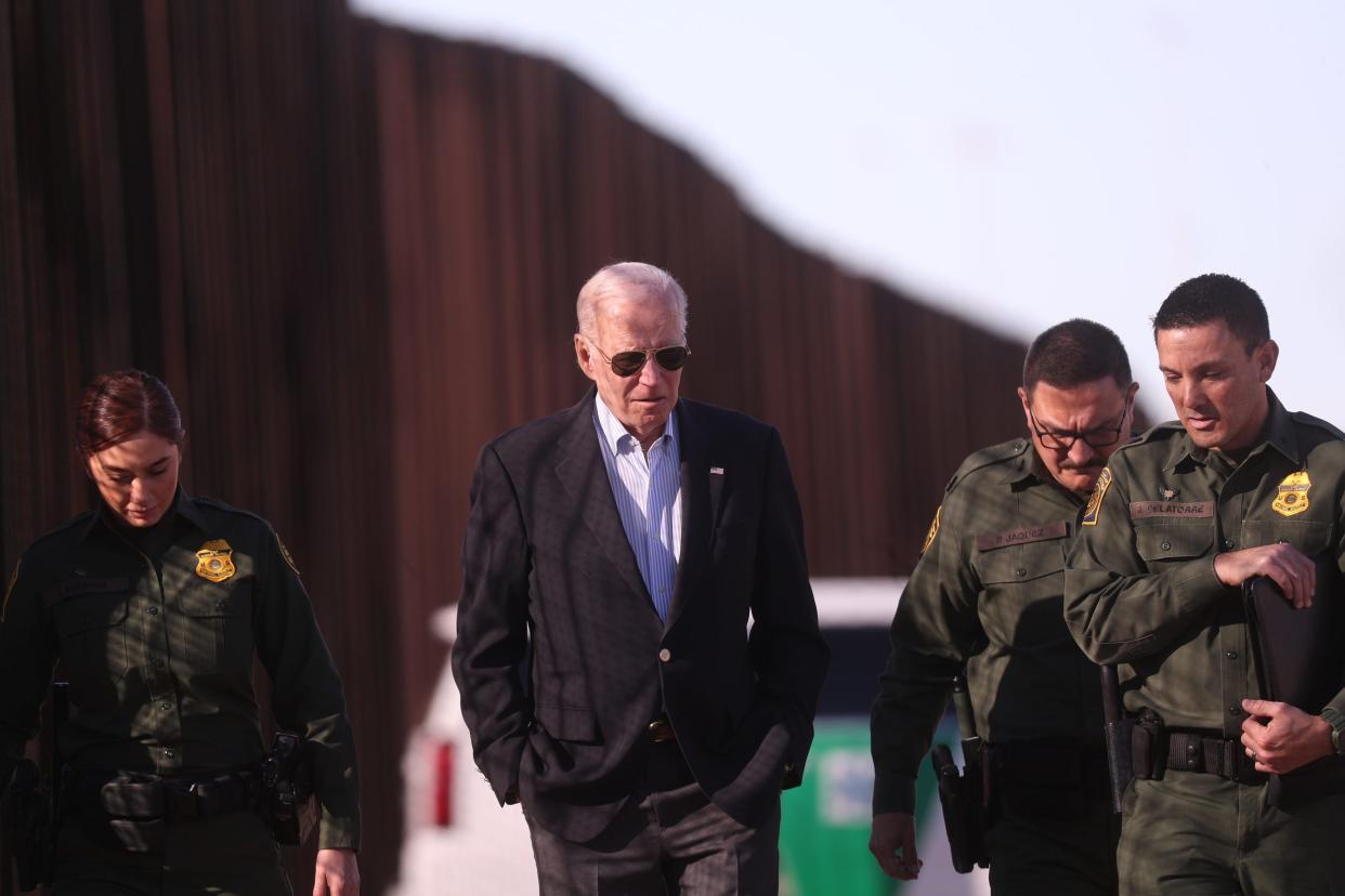 President Joe Biden walks along the border fence with Border Patrol agents on Jan. 8, 2023.