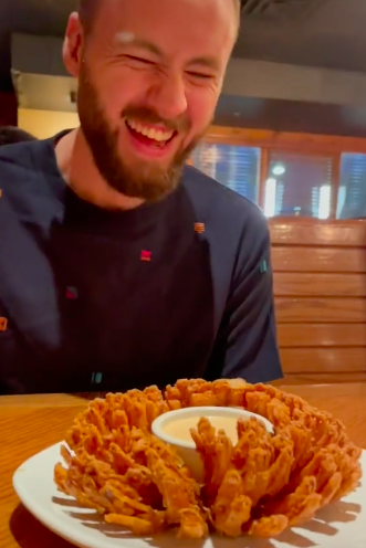 he smiling towering over a bloomin onion